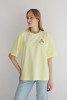 Koszulka oversize unisex w pastelowym żółtym kolorze z nadrukiem cannoli – Dolce Vita Tee inspirowana Sycylią