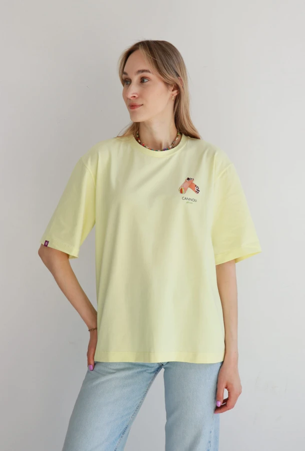 Koszulka oversize unisex w pastelowym żółtym kolorze z nadrukiem cannoli – Dolce Vita Tee inspirowana Sycylią