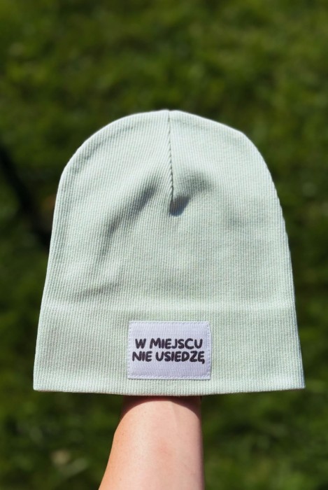 Seledynowa czapka dziecięca prążek z naszywką „W miejscu nie usiedzę”