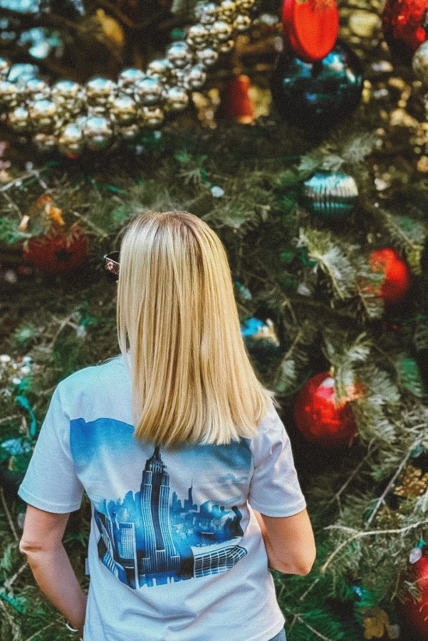 Koszulka podróżnicza z panoramą Nowego Jorku – widok z tyłu na modelce przy choince w Nowym Jorku