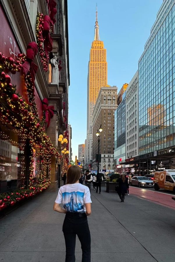Koszulka podróżnicza z panoramą Nowego Jorku – widok z tyłu na modelce z widokiem na Empire State Building